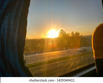 Bus Trip By Highway - View Of A Bus Window With Sunset On The Horizon, Details Of Armchair, Sun Reflection In Glass; Relaxation Concept