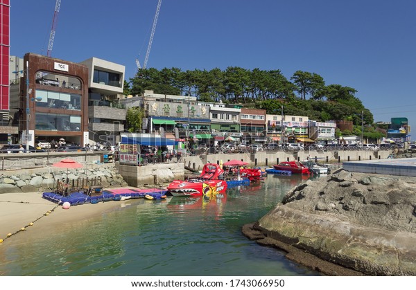 Busan,\
South Korea, September 14, 2019: exteriors of Songdo beach cafes\
and restaurants with boat renting place in\
front