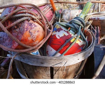 A Bushel Of Colorful Old Crab Pot Buoys And Boat Ropes Outside In The Sunlight.