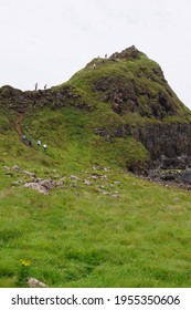 Bushmills, Northern Ireland - July 21 2014: People Climbing The Top Peak At The Giant's Causeway