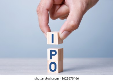 Busiiness Concept IPO Stack of wooden blocks with letters, Initial Public Offering IPO concept, random letters around, Blue tone background