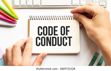 businesman hold notepad with text CODE OF CONDUCT. White background. Business
