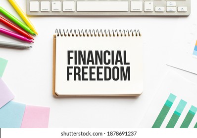 businesman hold notepad with text FINANCIAL FREEEDOM . White background. Business