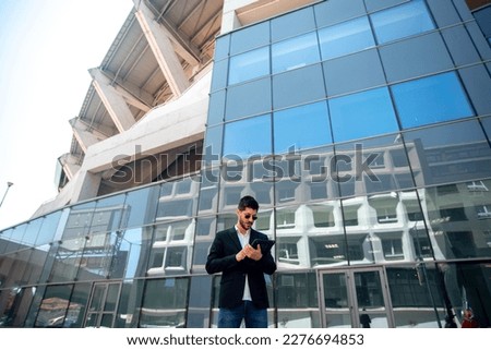 Businesman working on his tablet infront of the building