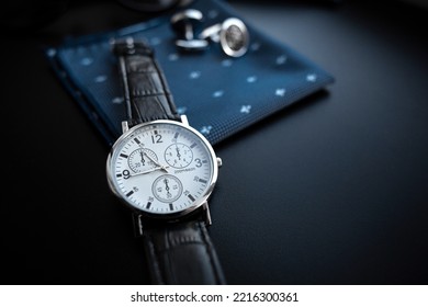 Business accessories. Mens watch and cufflinks isolated on black background. - Shutterstock ID 2216300361