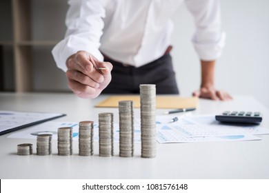 Business accountant or banker, businessman calculate and analysis with stock financial indices and putting growth stacking coin and financial costs wisely and carefully, investment and saving concept. - Shutterstock ID 1081576148