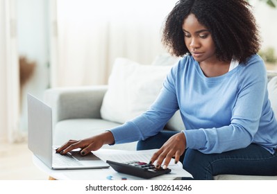 Business Accounting. African Businesswoman Using Calculator And Working With Laptop. Copy Space