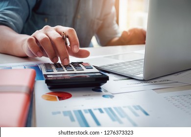 Business accounting concept  Business man using calculator and computer laptop  budget   loan paper in office  