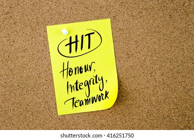 Business Acronym HIT Honour, Integrity, Teamwork Written On  Yellow Paper Note Pinned On Cork Board With White Thumbtack, Copy Space Available