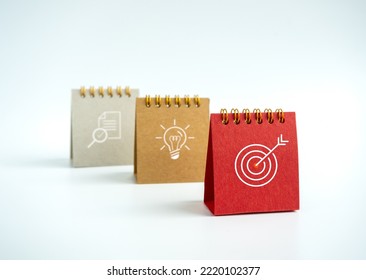Business action plan with goal,  idea and research icon signs on small red, beige and grey desk calendar year 2023 on white background. Three step of strategy concept, minimal style. - Shutterstock ID 2220102377