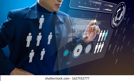 Business administrator in action of manpower or human resource planning or business organisation on a futuristic augmented reality virtual dashboard.