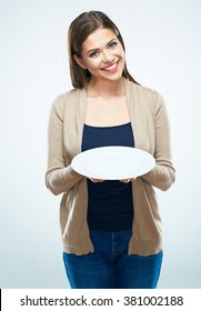 Business advertising concept with young smiling woman holding empty plate. Studio isolated portrait of female model with long hair.