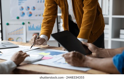 Business advisory meeting to analyze financial charts and review accounting documents. Meeting to discuss strategy analysis and business growth planning for the company's profits. - Powered by Shutterstock