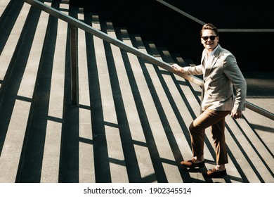 Business, ambitoins, people and lifestyle concept: Young Businessman climbing stairs. Summer day.