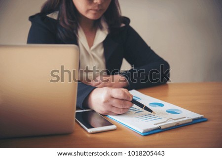 Business analysis - calculator, sheet, graphs (business report) and analyst hand