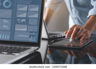 Business analysis and technology concept. Businessman and teamwork analyzing business data, marketing report monitoring dashboard on laptop computer and digital tablet on desk in office.
