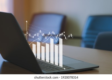Business analytics concept, financial bar charts to analyze profit and finance performance of company. Computer laptop on the wooden table
