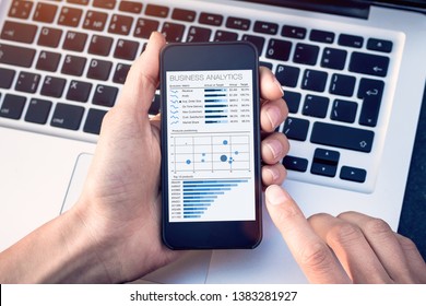 Business analytics dashboard on smartphone screen, analyst analyzing sales and operations data key performance indicators (KPI) charts and metrics