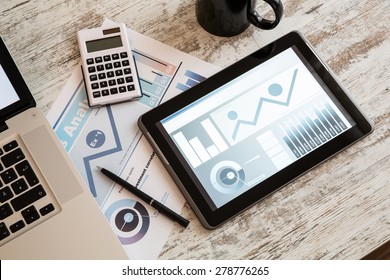 Business Analytics On A Wooden Desk With A Tablet PC And A Laptop.