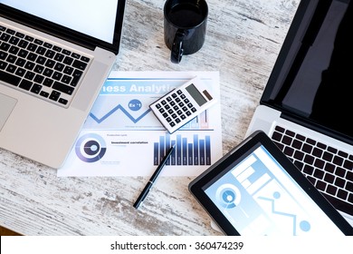 Business Analytics On A Wooden Desk With A Tablet PC And A Laptop.
