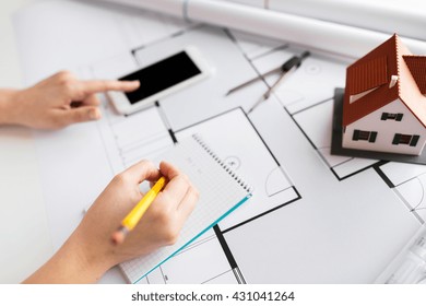 business, architecture, building, construction and people concept - close up of architect hand with living house blueprint and smarphone writing to notebook - Shutterstock ID 431041264