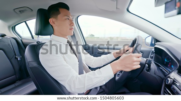 business
asia man driving happily in the car on
highway
