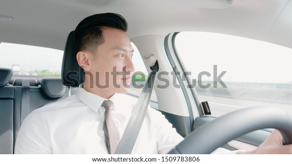 business\
asia man driving happily in the car on\
highway