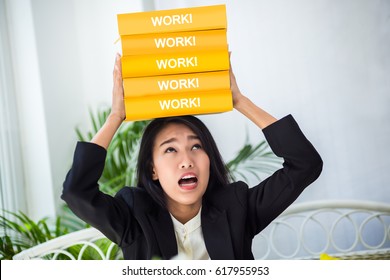 business asian gril try to balance stack of heavy book on her head with funny emotion face business ideas concept