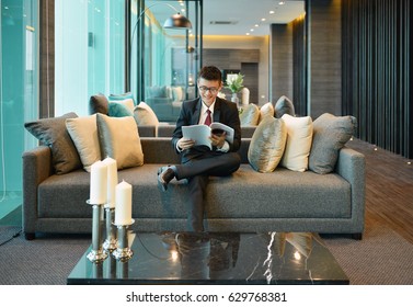 Business Asian man reading a book on sofa in luxury condo - Shutterstock ID 629768381