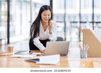 Business Asian woman freelancer is working her job on a laptop computer and phone call in the office. Doing accounting analysis report real estate investment data, Financial and tax systems concept.	 - Powered by Shutterstock