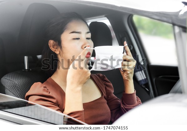 business Asian woman wearing protective mask before\
driving car to work during covid-19 outbreak, new normal lifestyle\
concept 