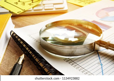 Business assessment and audit. Magnifying glass on a financial report.