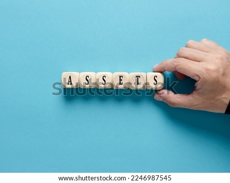 Business assets. Asset management and financial accounting concept. Male hand arranges the wooden cubes with the word assets.