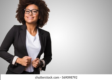 business black woman adjusting her clothes on a grey background