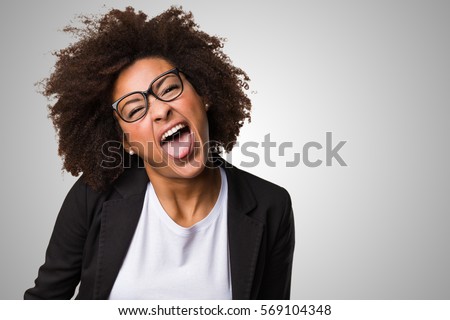 business black woman showing tongue on a grey background