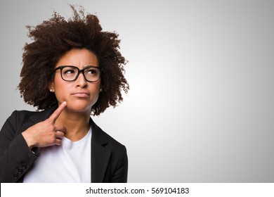 business black woman thinking on a grey background - Shutterstock ID 569104183