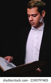 Business Blond Man Reviewing Papers In A Briefcase. Business Executive Reading Important Papers. Man In Black Suit With White Shirt. High Quality Photo