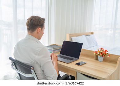 Business blonde, white man, caucasien travaillant à la maison sur table avec ordinateur portable portable et espace écran vierge sur webcam vidéoconférence en quarantaine dans le concept de virus corona.