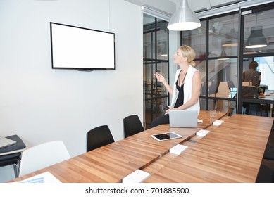 Business Blonde Woman Watching TV With Blank Screen In Office