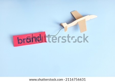 Business branding campaign success and launching concept. Airplane flying with brand tag in blue background with copy space.