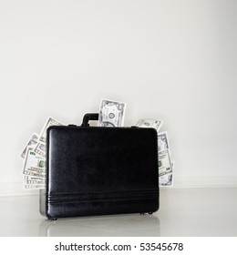 Business briefcase overflowing with cash money.