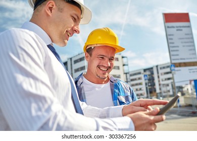 Business-, Bau-, Teamwork-, Technologie- und People-Konzept - lächelnde Bauer in Hardhats mit Tablet PC-Computer im Bau