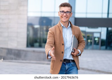 Business. Businessman Giving Hand For Handshake Welcome Gesture Adult Caucasian Male Business Person Holding Closed Laptop Give Hand Ready Handshake Office Building Background