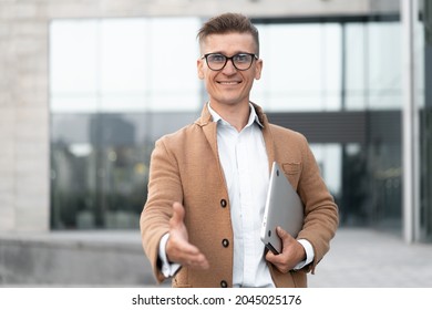 Business. Businessman Giving Hand For Handshake Welcome Gesture Adult Caucasian Male Business Person Holding Closed Laptop Give Hand Ready Handshake Office Building Background