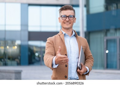 Business. Businessman Giving Hand For Handshake Welcome Gesture Adult Caucasian Male Business Person Holding Closed Laptop Give Hand Ready Handshake Office Building Background