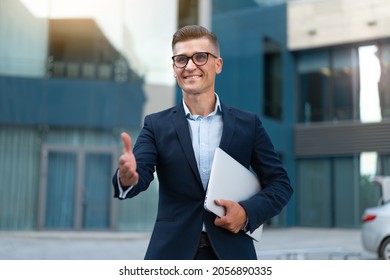 Business. Businessman Giving Hand For Handshake Welcome Gesture Adult Caucasian Male Business Person Holding Closed Laptop Give Hand Ready Handshake Office Building Background