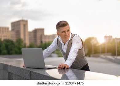 Business. Businessman Using Laptop Outdoors. Serious Pensive Caucasian Male Business Person Computer Outside Modern Technology Concept Young Adult Manager Crisis Thinking Trouble Idea 