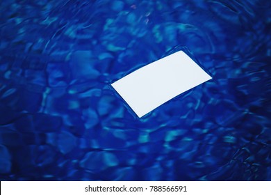 Business Card Floating On The Water In The Pool. Blurred Background Water.