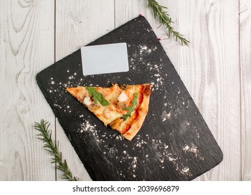 Business Card Mockup For Presenting Design Italian Restaurant. Pizza On Stone Tray Blackboard And On A Wooden Table With White Business Card Mockup