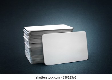 Business Cards With Rounded Corners. The Pile Of Blank Business Cards Lays Propped Up Another Business Card.